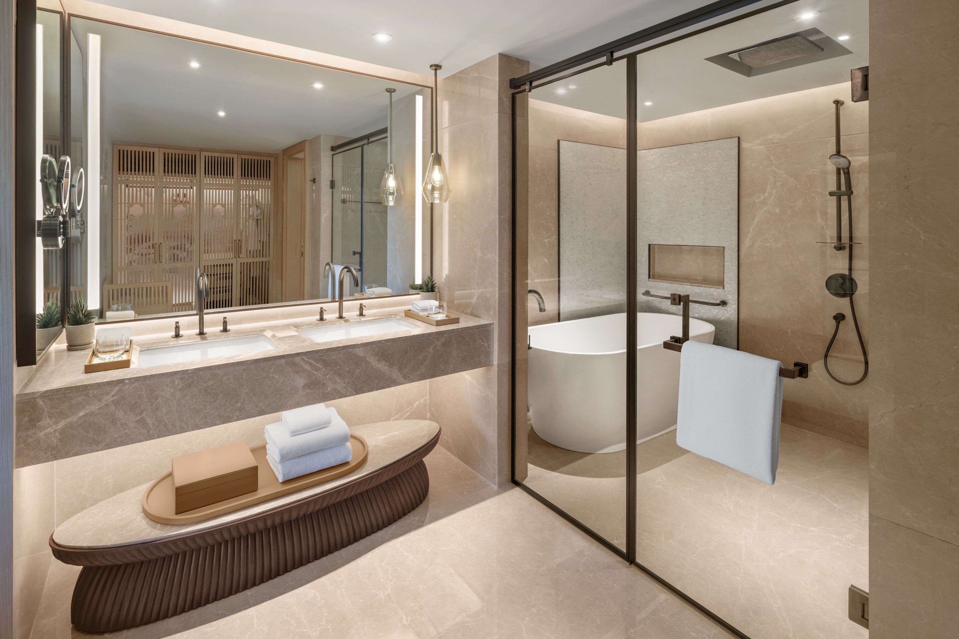 A modern bathroom with a large mirror, a bathtub, and a shower area.