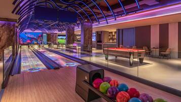 A bowling alley with a modern design, including a wooden floor and a bowling ball return area.