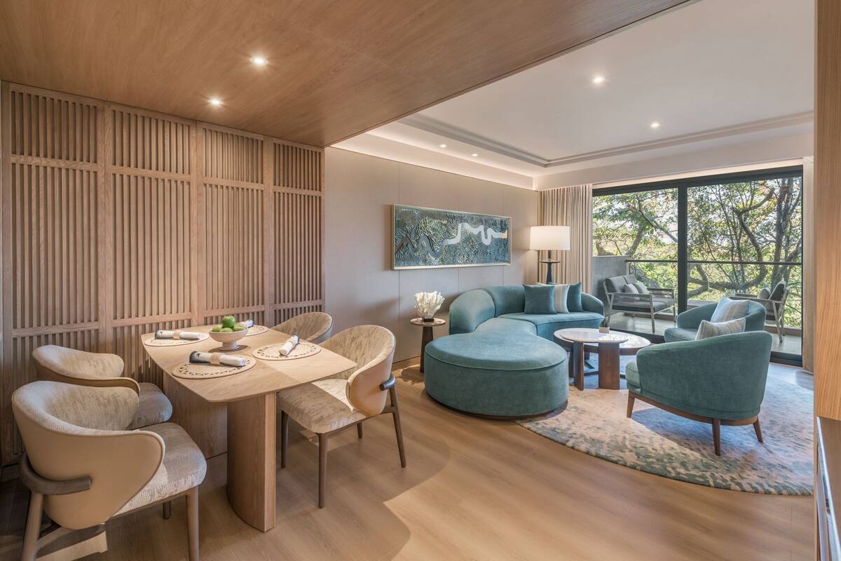 A modern living room with a wooden ceiling, a dining area with a table and chairs, and a seating area with sofas and a coffee table.