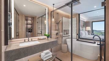 Un baño moderno con un espejo grande, una bañera y una zona de ducha.