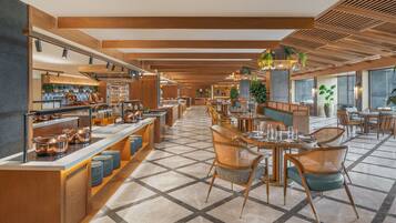 Un hall d’hôtel moderne avec un espace de restauration central, un comptoir d’accueil et un buffet.