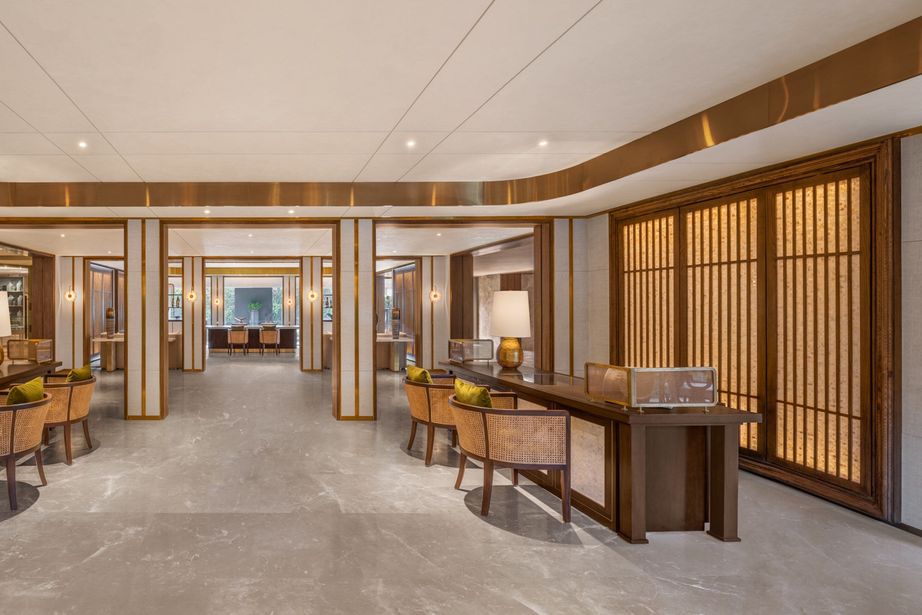 A spacious lobby with a reception desk, seating area, and large windows.