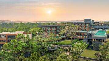 Experience the serene atmosphere of our hotel complex, surrounded by lush greenery and a tranquil pool area.