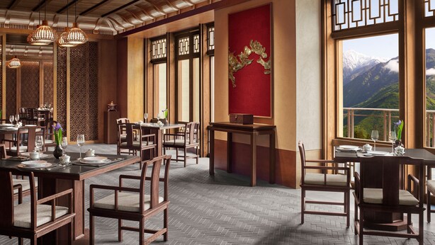 A restaurant with wooden furniture, a red accent wall, and a view of mountains. - Rissai Valley, a Ritz-Carlton Reserve (Ngawa Autonomous Prefecture)