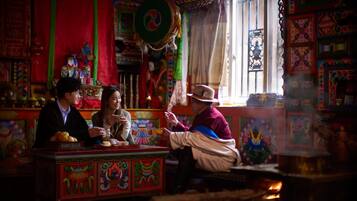 A traditional room with colorful decorations, a prayer wheel, and a fire.