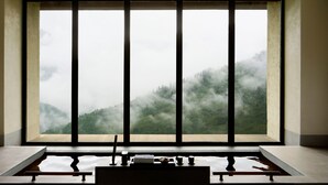 A room with a large window overlooking a forested mountain range. - Rissai Valley, a Ritz-Carlton Reserve (Ngawa Autonomous Prefecture)