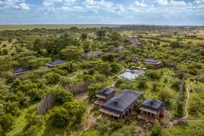 Conjunto de cabañas ecológicas rodeadas de exuberante vegetación, con vistas despejadas del paisaje y una piscina.