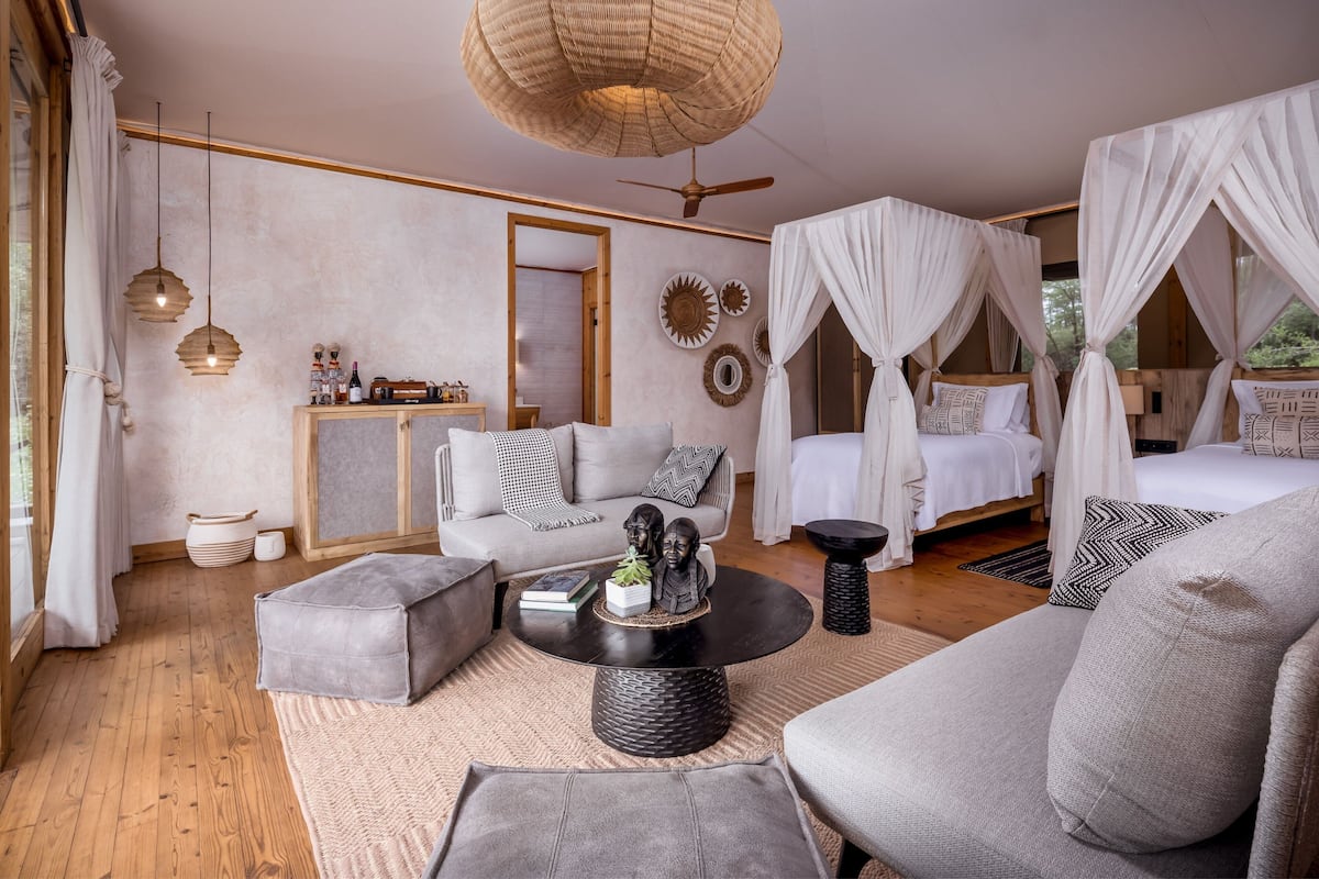 Una habitación amplia con una cama grande, un sofá, una mesita de centro y un ventilador de techo.
