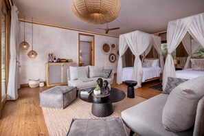 Una habitación amplia con una cama grande, un sofá, una mesita de centro y un ventilador de techo.