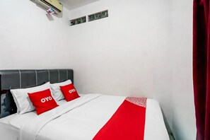 A bed with a white and red bedspread, two red pillows with "oyo" text, and a grey headboard. - Hotel O Wilson HomestayNearRSU Bunda Thamrin (Medan)