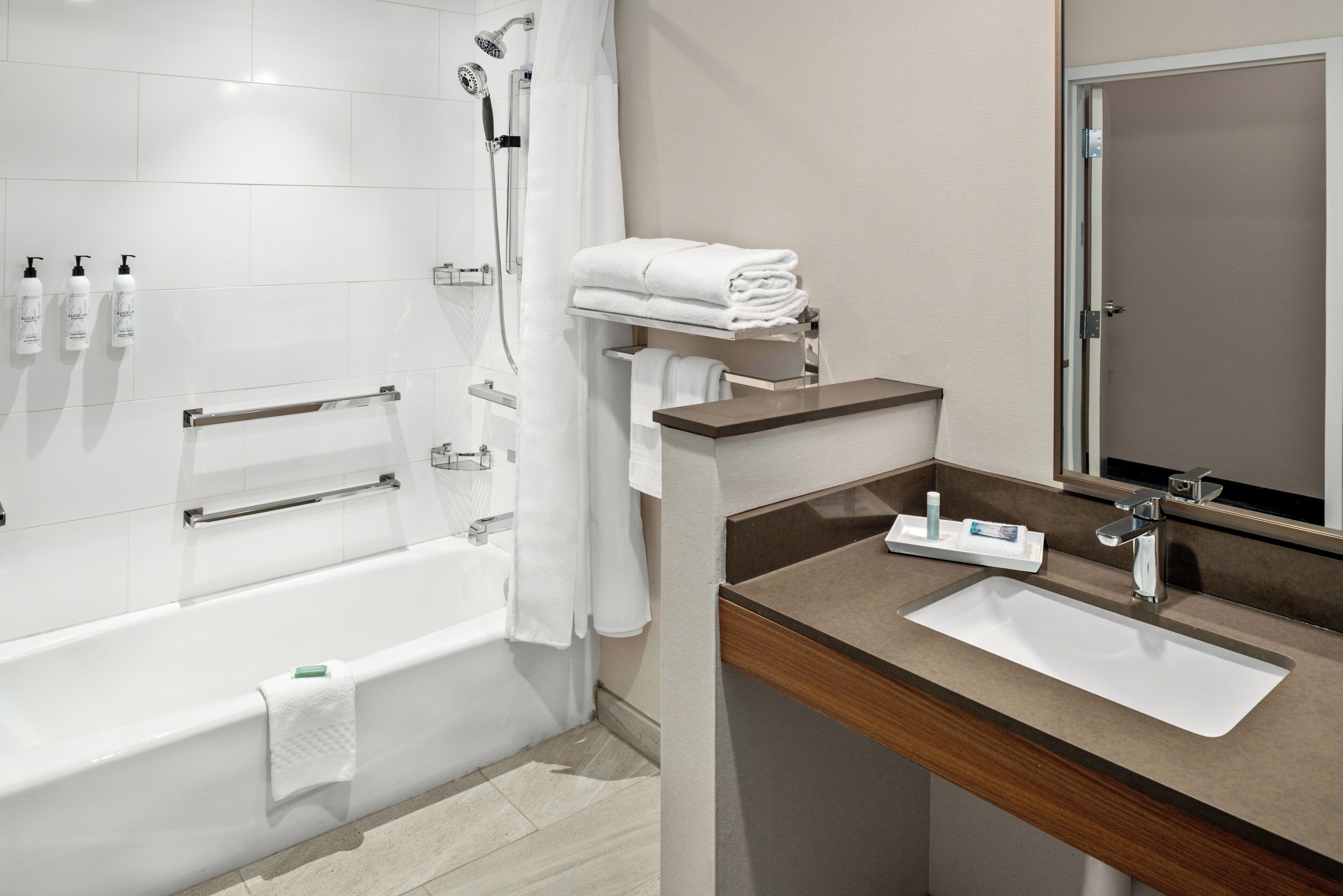 Ein modernes Badezimmer mit Badewanne, Dusche, Waschtisch und Spiegel.