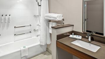 Ein modernes Badezimmer mit Badewanne, Dusche, Waschtisch und Spiegel.