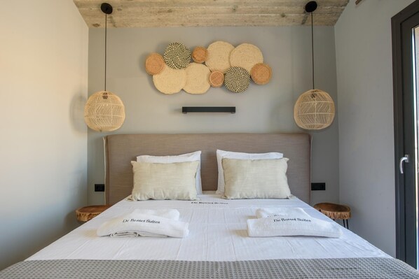 A neatly made bed with two pillows, a bedside table, and a wall-mounted decorative item.
