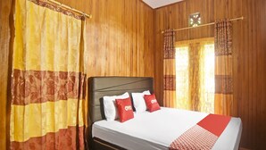 A hotel room with a wooden paneled wall, a bed with white bedding and red pillows, and a patterned red and white bed runner. - OYO Homes 91118 Homesstay Desa Wisata Budo Near Desa Wisata Budo (Wori)