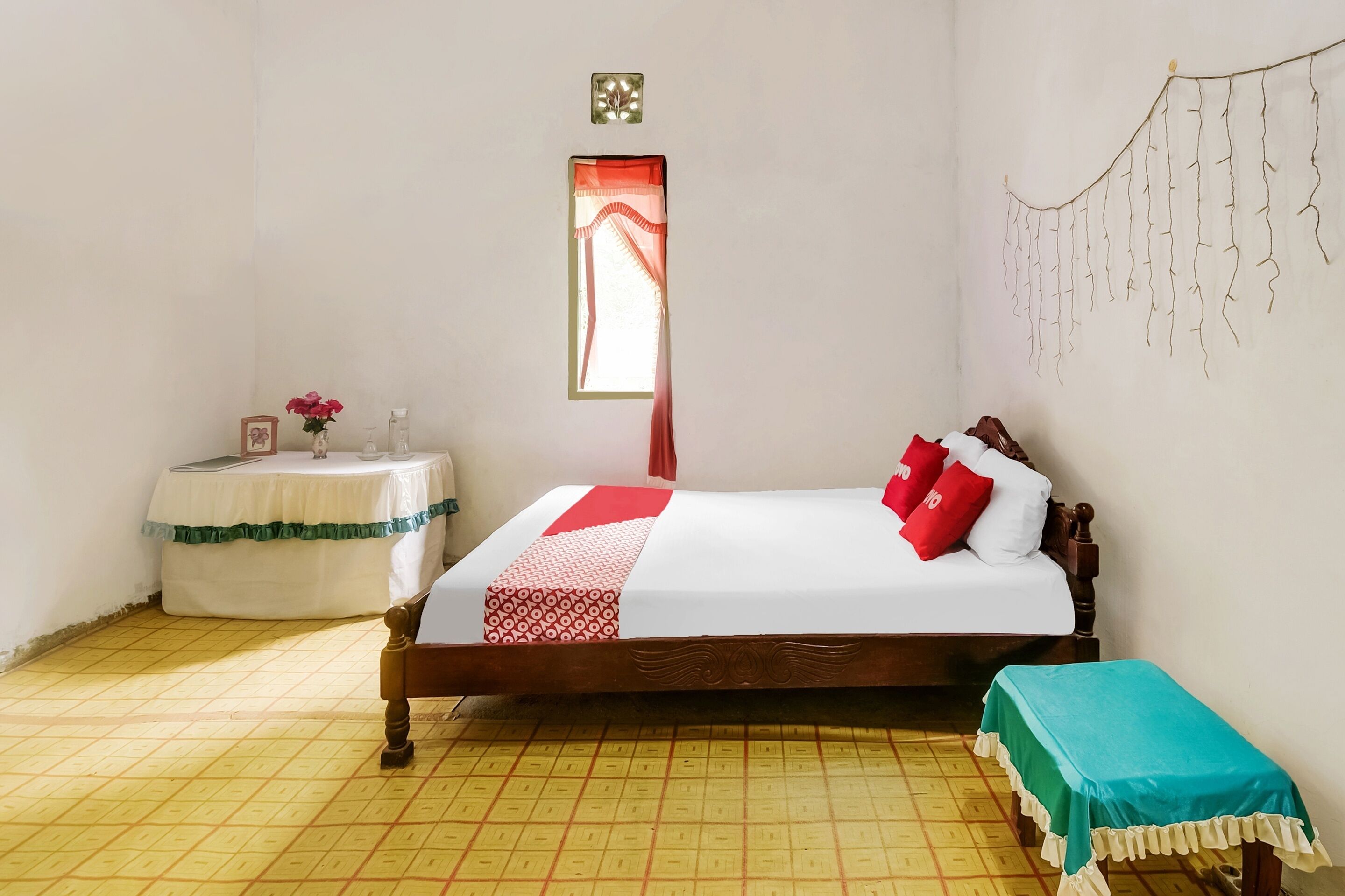 Een keurig opgemaakt slaapkamer met een bed, nachtkastje en een klein bankje.