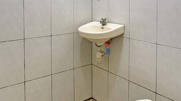 Ein Badezimmer mit Toilette, Waschbecken und Fliesenboden mit Muster.