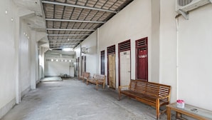 A hallway with benches and doors, some with numbers.