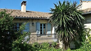 A traditional building with a tiled roof, a visible chimney, and a metal fence. - La Paillère (Mus)