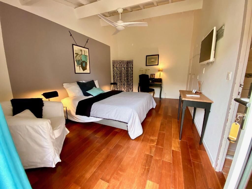 Een slaapkamer met een bed, twee nachtkastjes, een bureau en een stoel.