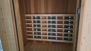A sauna room with wooden walls and a metal grate floor. - Villa Elie (Malmedy)