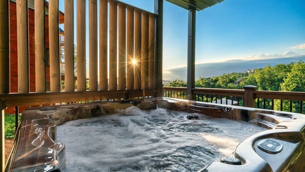 Un bain à remous installé sous une terrasse en bois, offrant une vue magnifique.