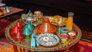 A traditional Moroccan table set with a variety of dishes, drinks, and utensils. - Riad SofYan (Marrakech)