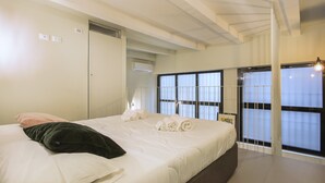 A bedroom with a large bed, a wardrobe, an air conditioning unit, and a window with blinds. - Modern Loft in Porta Venezia (Milan)