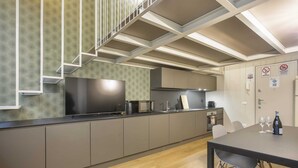 A modern kitchen with grey cabinets, a black countertop, and a built-in microwave. - Modern Loft in Porta Venezia (Milan)