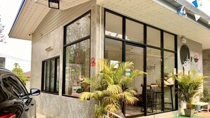 A building with large windows and a car parked in front. - Instyle place (Chiang Rai)