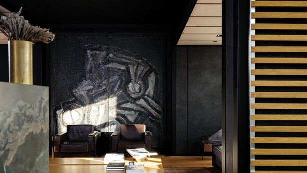 A modern reception area with a large abstract wall art, a reception desk, two leather chairs, and a wooden floor. - Magnificent High-end 2-bedroom Apartment in Gent (Ghent)