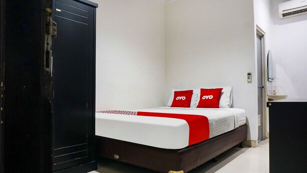 A bedroom with a bed, a wardrobe, and a desk.