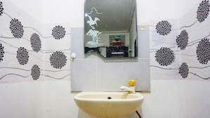 A bathroom with a sink, mirror, and decorative wall tiles.