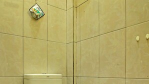 A bathroom with a toilet, a bidet, and a hand dryer on the wall. - OYO Life 91268 Homestay Bu Erma Syariah (Palembang)