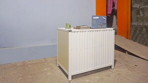 A white radiator with a small table on top, a laptop, and a green object on the table.