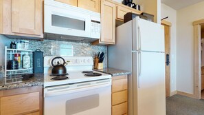 Enjoy cooking in this well-equipped kitchen with a stove, refrigerator, and ample countertop space.