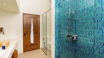 Un baño con puerta de madera, un lavabo blanco y una zona de ducha con azulejos azules.