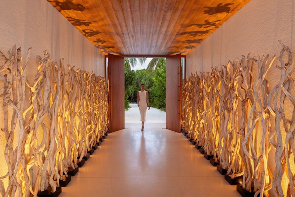 Un pasillo con techo de madera y paredes decoradas con detalles de madera natural.
