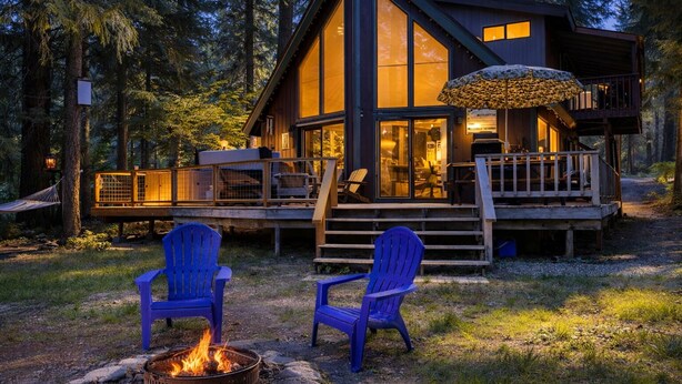 A cabin with a deck, two blue Adirondack chairs, and a fire pit. - Jack's Cabin 2 Bedroom Home by NW Comfy Cabins (Leavenworth)