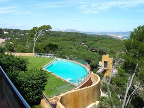 Una piscina circondata da rigogliosa vegetazione, con vista su dolci colline e un cielo sereno.