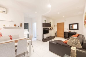 Apartament bàsic, 2 llits dobles | Sala d'estar | Televisor 