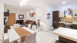 A modern kitchen with white cabinets, a gas stove, and a tiled backsplash. - Bluemarine Suite (St. Julian's)