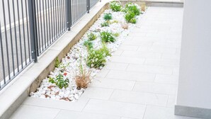 A pathway with white pebbles and small plants, bordered by a metal railing. - Apt24 - Garibaldi 1 in Desenzano del Garda (Desenzano del Garda)