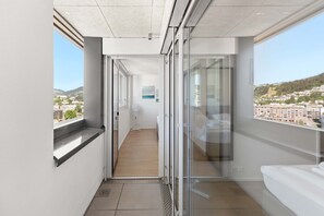 A modern hotel room with a balcony, a view of the city, and a large window. - 2BR Apt | Pilatus View | Near Lucerne (Kriens)