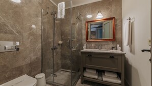 A modern bathroom with a glass-enclosed shower, a vanity with a mirror, and a toilet. - oDam Otel (Urla)