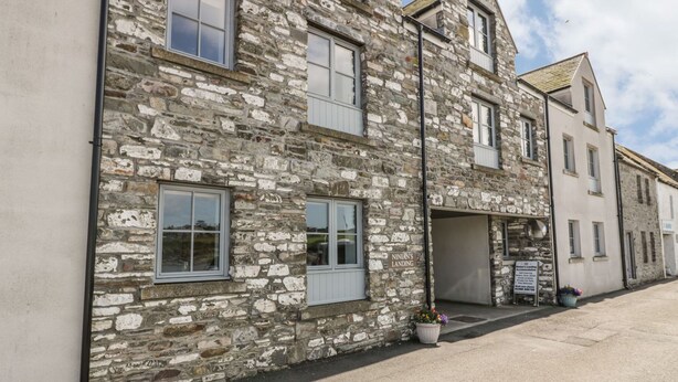 A stone building with multiple windows and a sign indicating 'Ninian's Landing'. - Tides Reach (Newton Stewart)