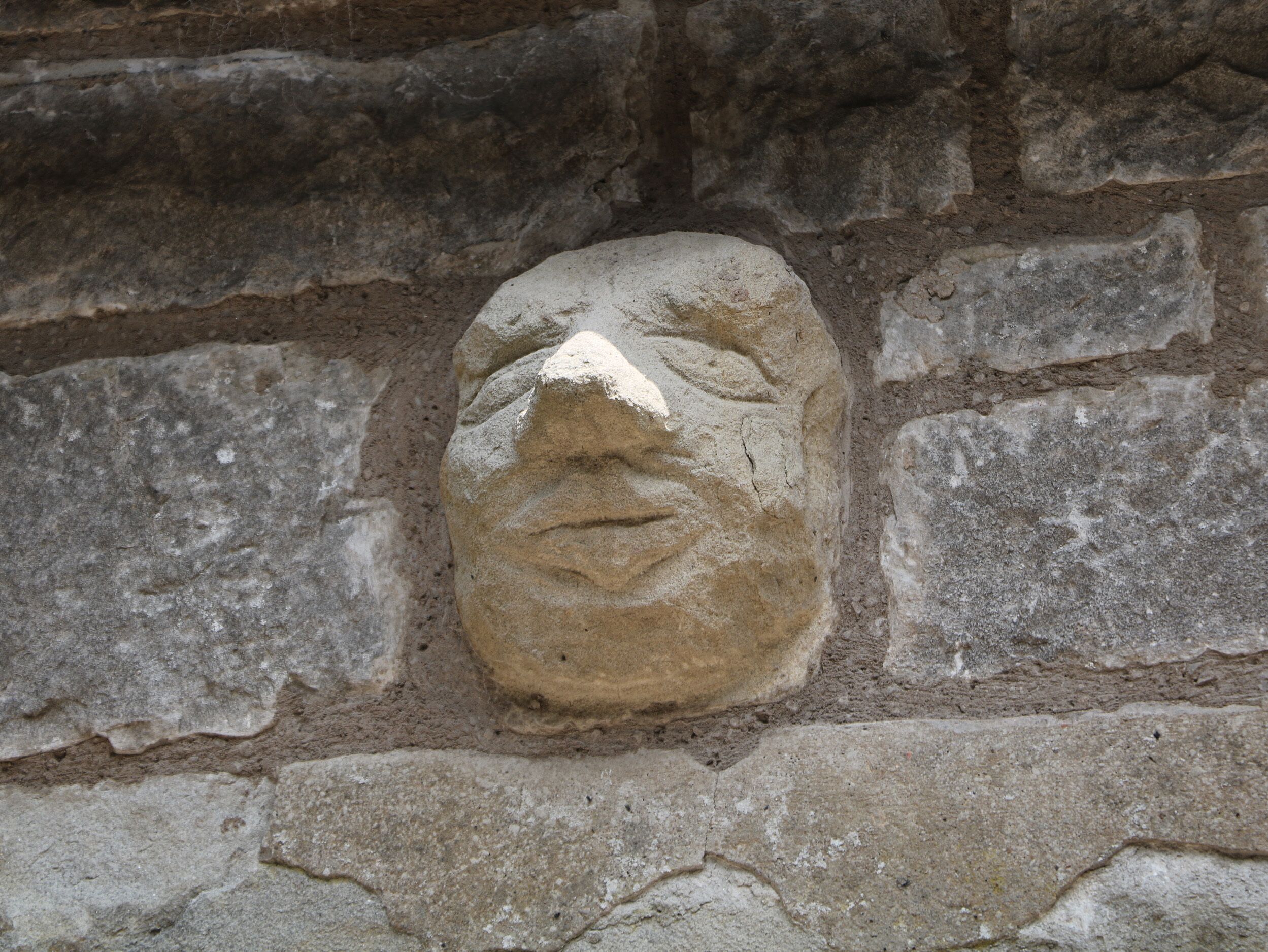 A stone face carved into a wall.