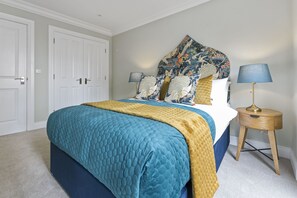 A bedroom with a bed, two bedside tables, a nightstand, and a door. - Wilton House (Belfast)