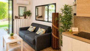 Una sala de estar moderna con un sofá, una mesa de centro y una zona de cocina con un fregadero y armarios.