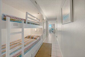 A bunk bed room with a hallway leading to a bathroom. - Pelican Beach 0805 1 Bedroom Condo by Pelican Beach Management (Destin)