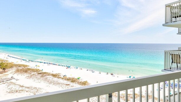 A beach view from a balcony with a railing, a clear sky, and the ocean. - Pelican Beach 1414 2 Bedroom Condo by Pelican Beach Management (Destin)